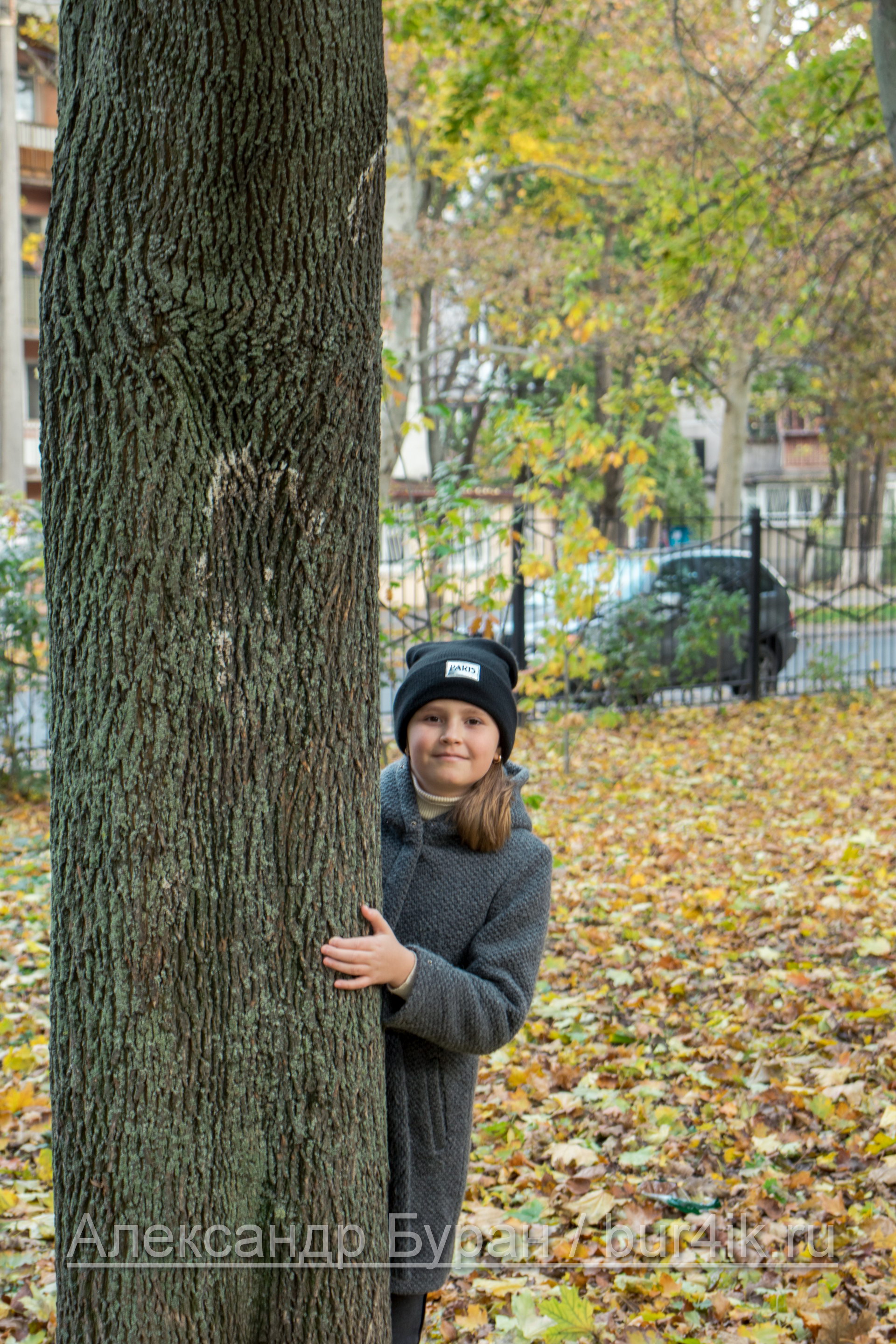 Девушка в пальто и шляпе прячется за деревом в осеннем парке - Украина, Одесса, 17,10,2019