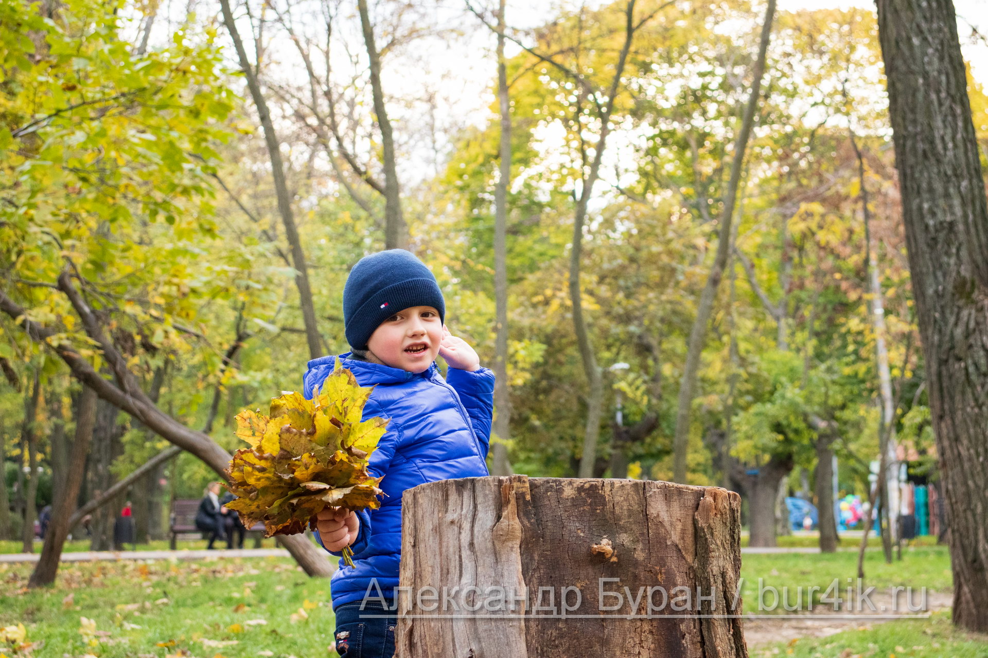 Мальчик откидывается на пене в осеннем парке