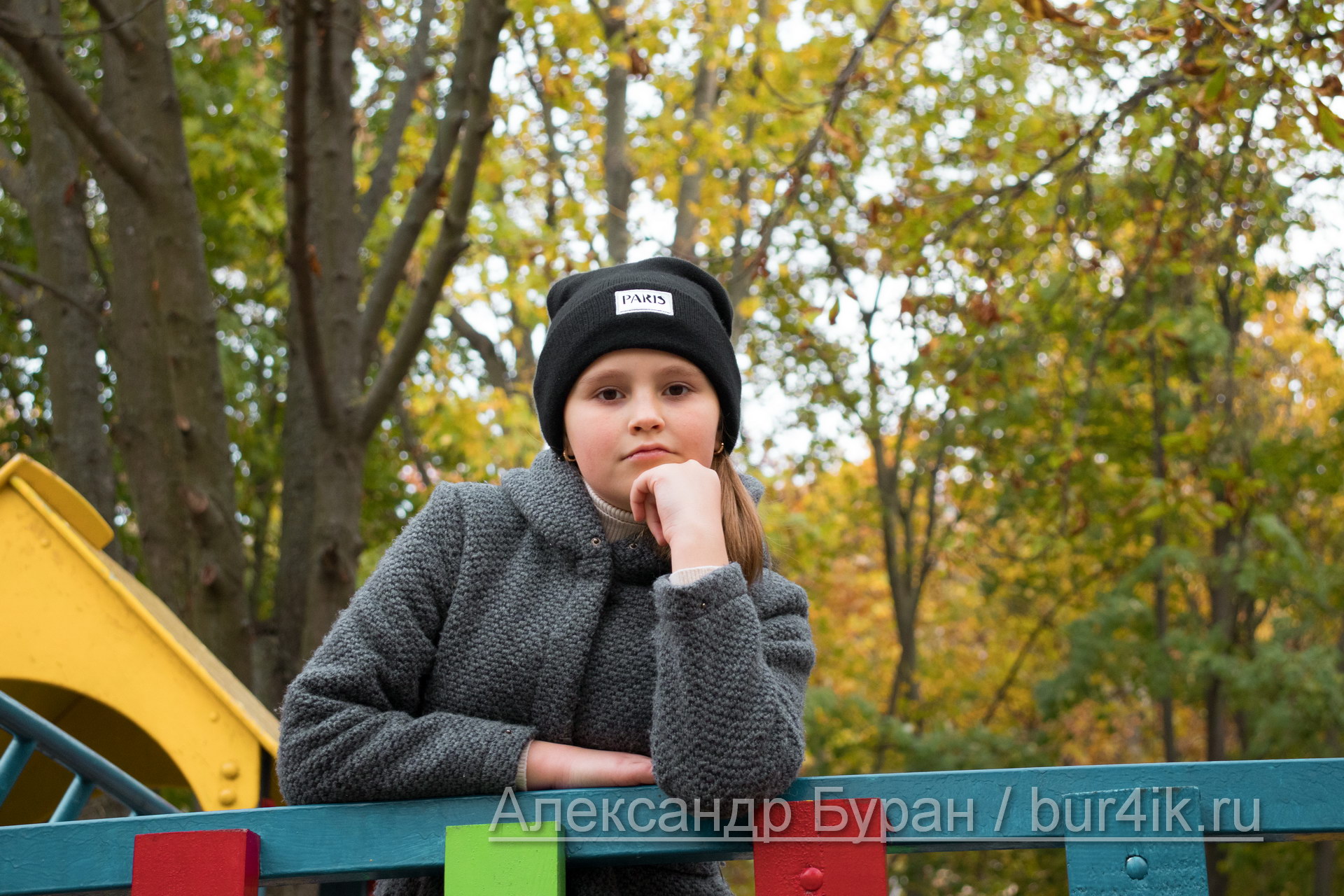 Девочка-подросток смотрит в камеру, стоя на деревянной площадке в парке осенью - Украина, Одесса, 17,10,2019