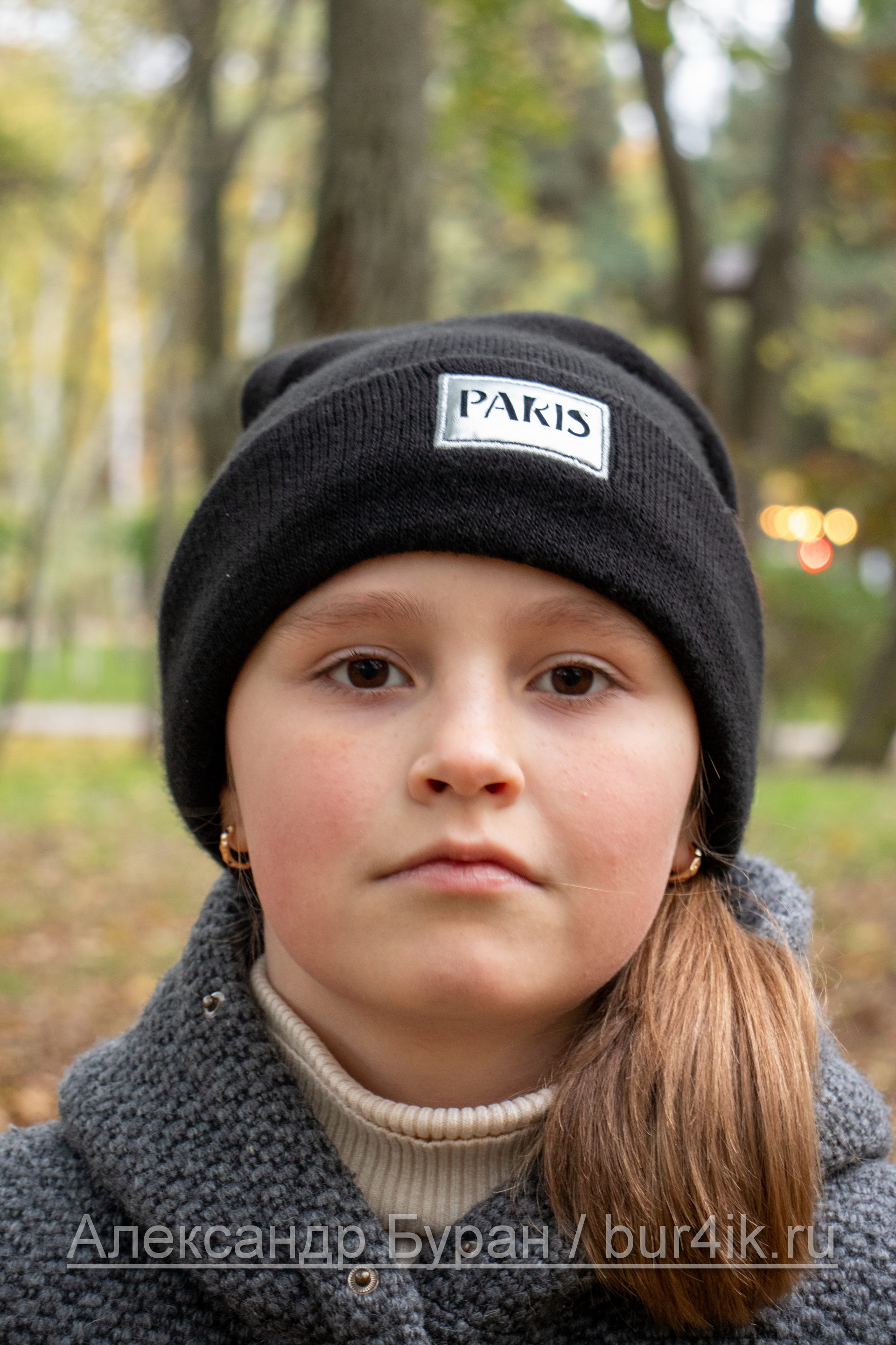 Портрет девушки в черной шляпе в парке осенью