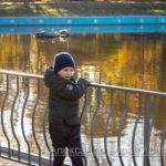 Мальчик ходит вокруг пруда в парке