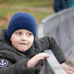 Мальчик, облокотившись на металлические перила забор вокруг пруда в парке
