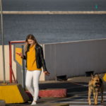 Девушка выгуливает свою собаку на причал для судов в морском порту - Украина, Одесса, 09,11,2019