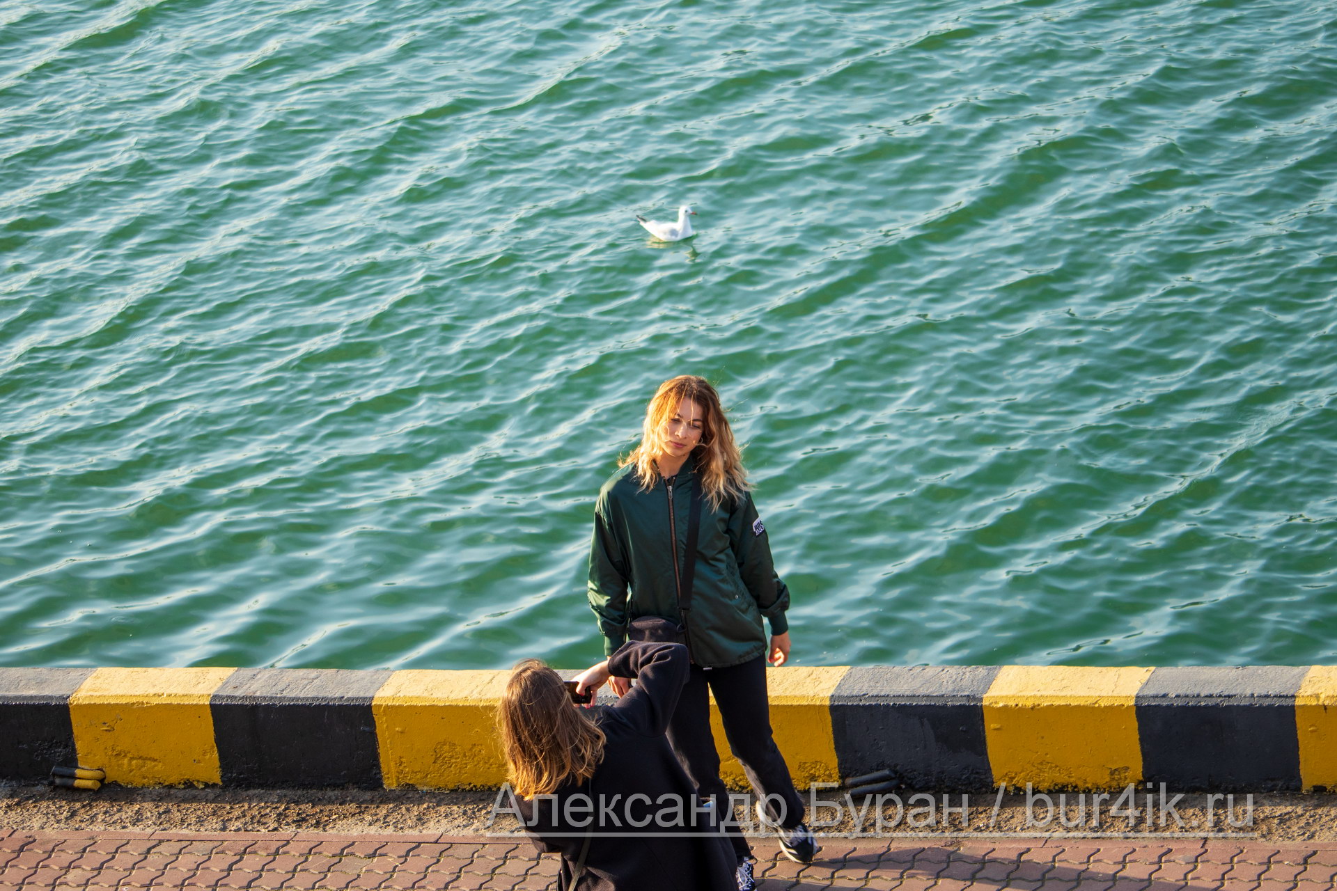 Две девушки фотографируют себя на причале в порту - Украина, Одесса, 09,11,2019