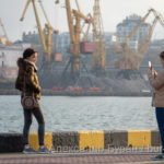 Две молодые девушки фотографируются в морском порту на фоне кранов - Украина, Одесса, 09,11,2019