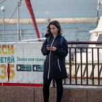 Девушка в черном пальто и с телефоном в руках в ожидании кого-то в порту у моря - Украина, Одесса, 09,11,2019
