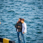 Два парня арабской внешности фотографируются на берегу моря в морском порту - Украина, Одесса, 09,11,2019