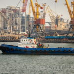 Маленький порт корабль плывет по акватории порта на фоне кранов - Украина, Одесса, 09,11,2019