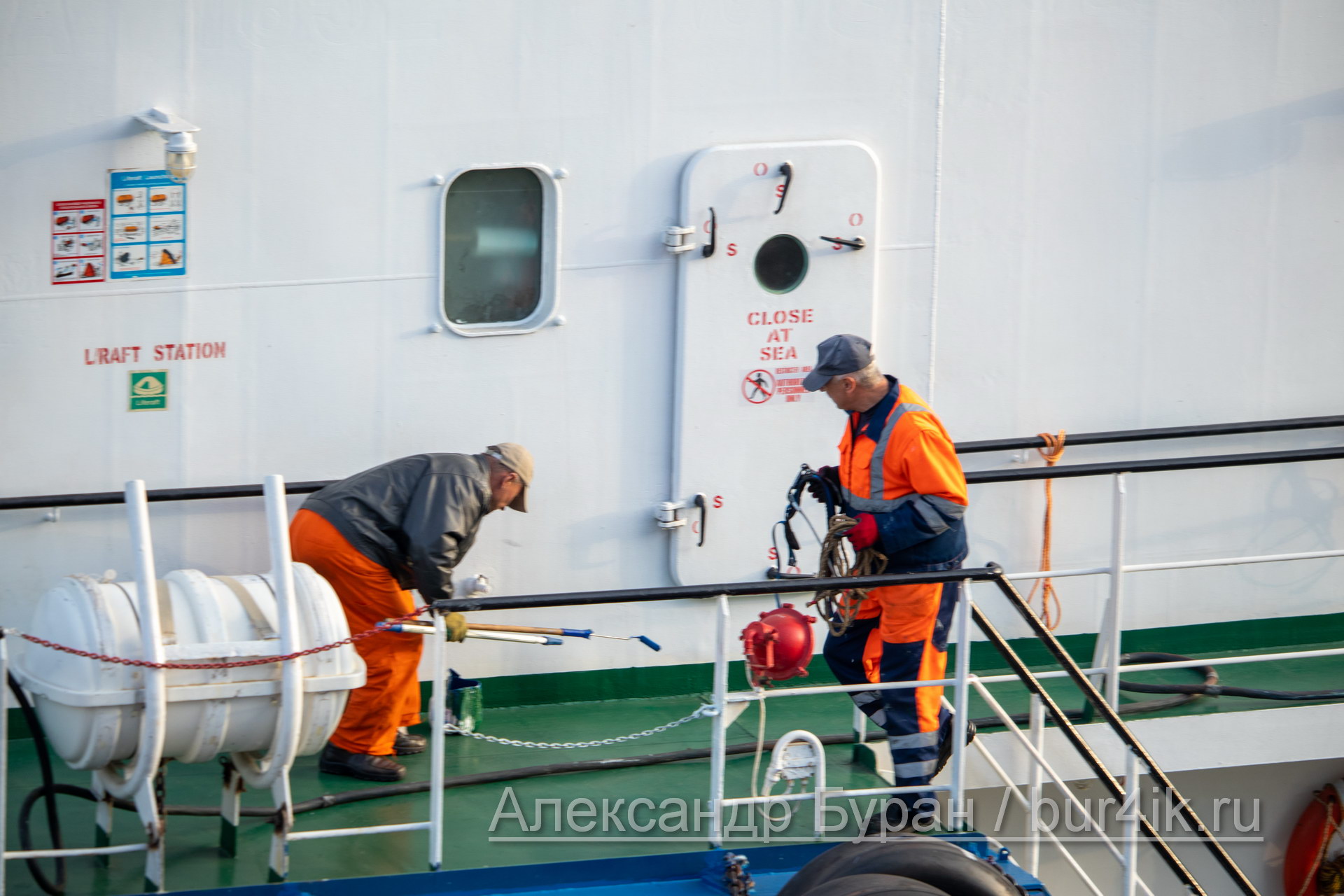 Двое мужчин на борту корабля выполняют работы по покраске палубы - Украина, Одесса, 09,11,2019