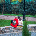 Мальчик и девочка подростки целуются в парке осенью
