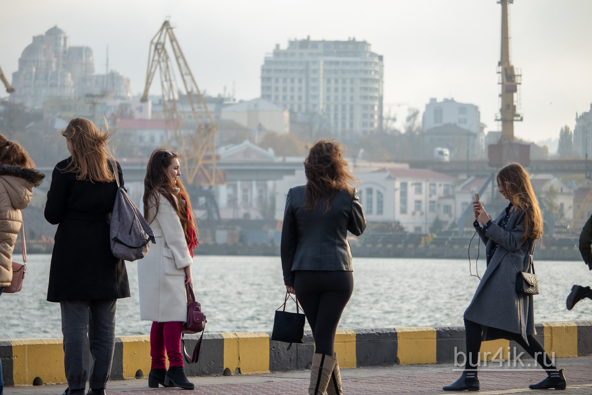 Группа девушек делает фото в порту