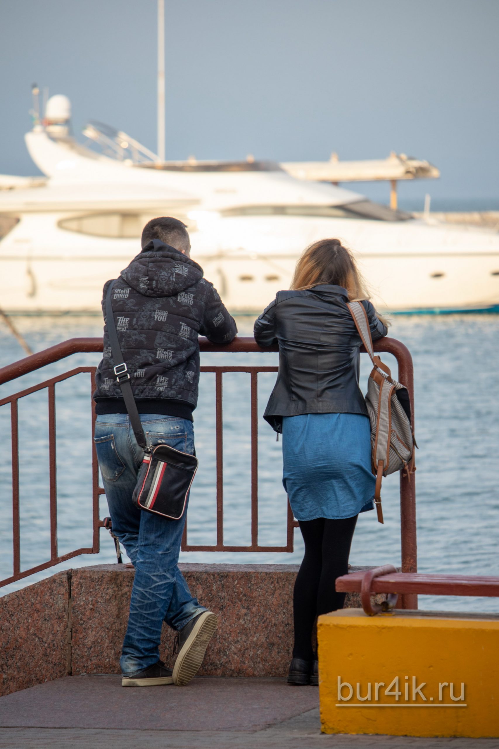Мужчина и женщина смотрят на яхты в