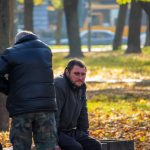 Бездомный мужчина с синяком под глазом и его товарищ на скамейке в парке осенью – bur4ik.ru фото 2