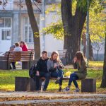 Две девушки и парень сидят на скамейке в парке осенью – bur4ik.ru фото 2