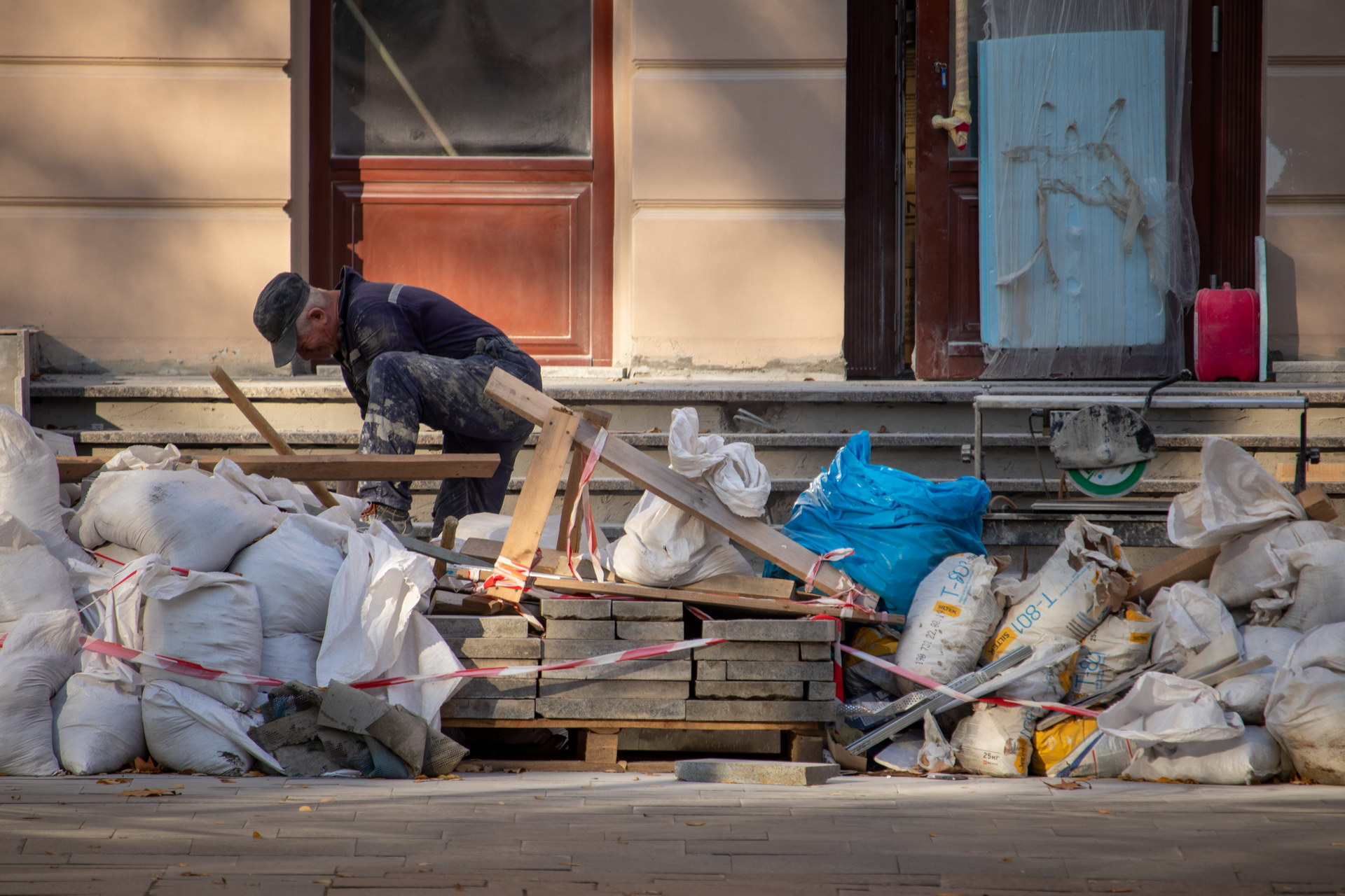Мужчина выполняет строительные работы на ступеньках у входа в здание – bur4ik.ru – 21.01.2020 - фото 1