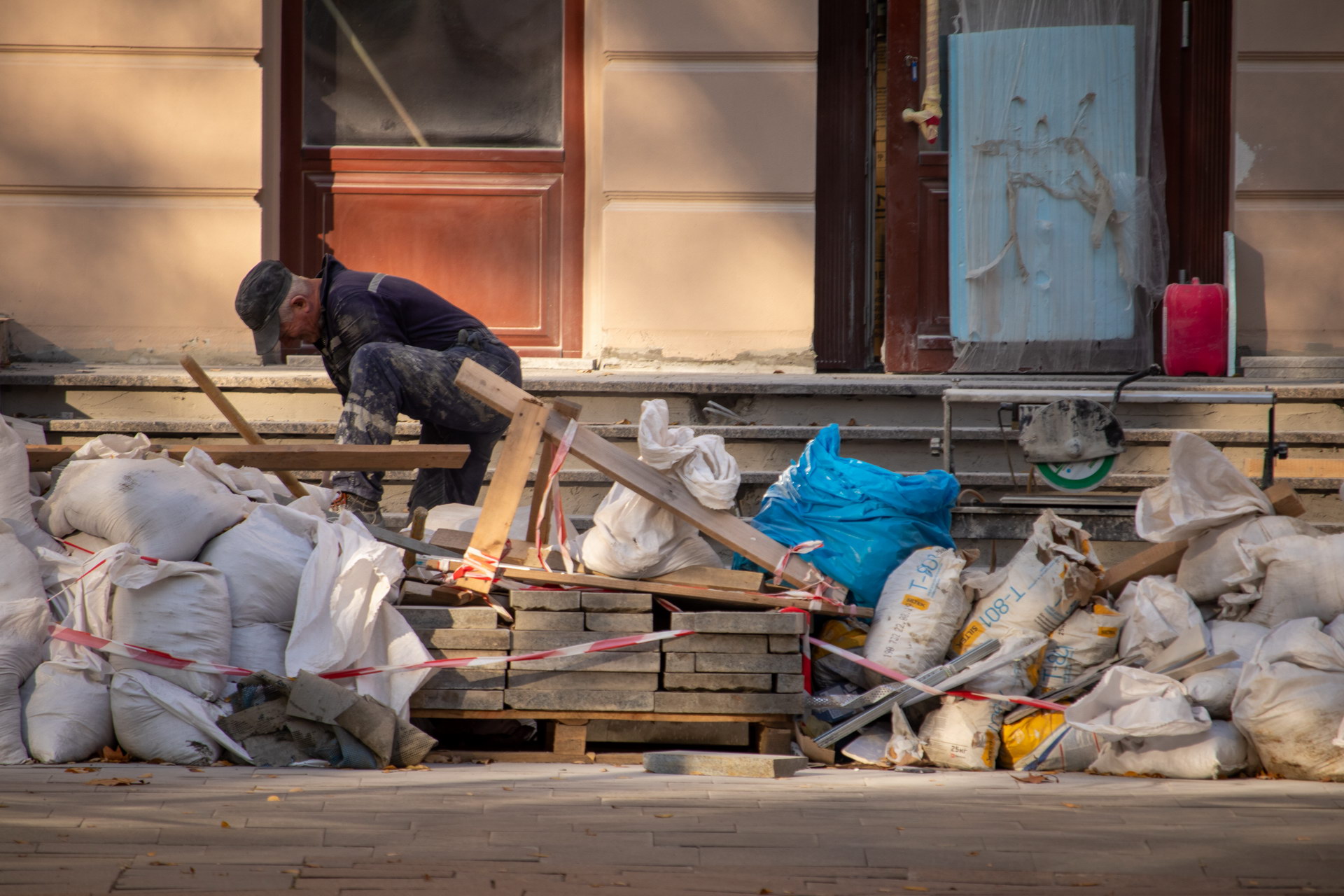 Мужчина выполняет строительные работы на ступеньках у входа в здание – bur4ik.ru – 21.01.2020 - фото 2