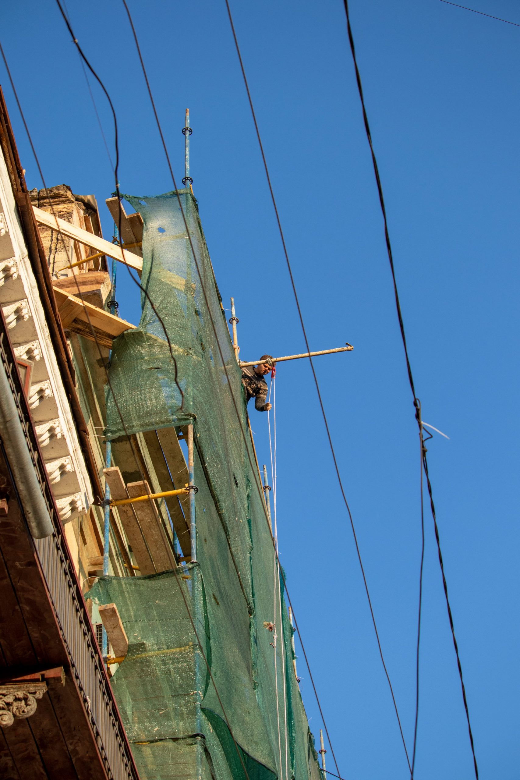 Мужчина поднимает ведро на крышу старинного здания ведя ремонт – bur4ik.ru – 21.01.2020 - фото 1