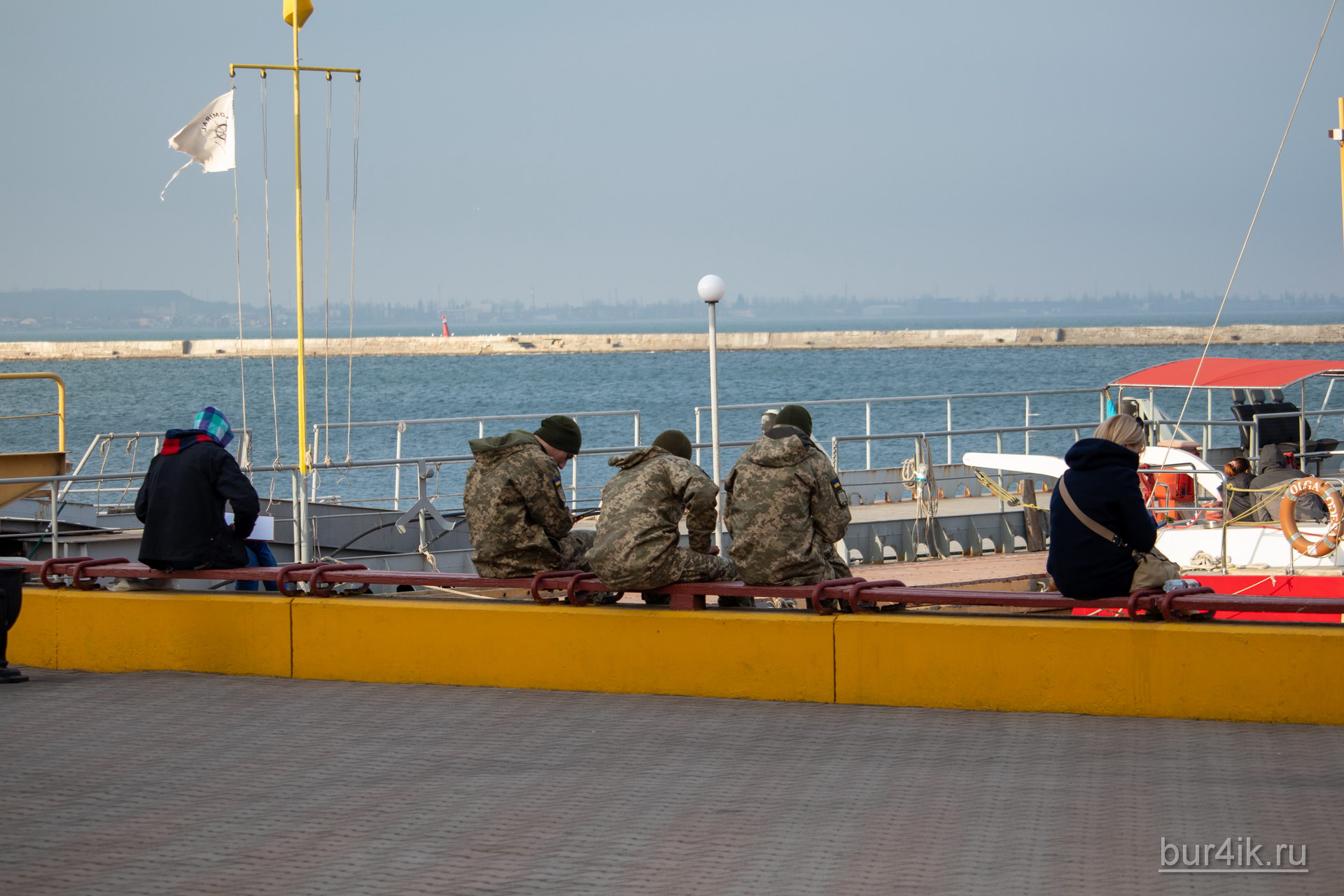 Военные сидят на скамейке у причала в порту в городе Одесса 2
