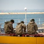 Военные сидят на скамейке у причала в порту в городе Одесса 3