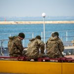 Военные сидят на скамейке у причала в порту в городе Одесса 4