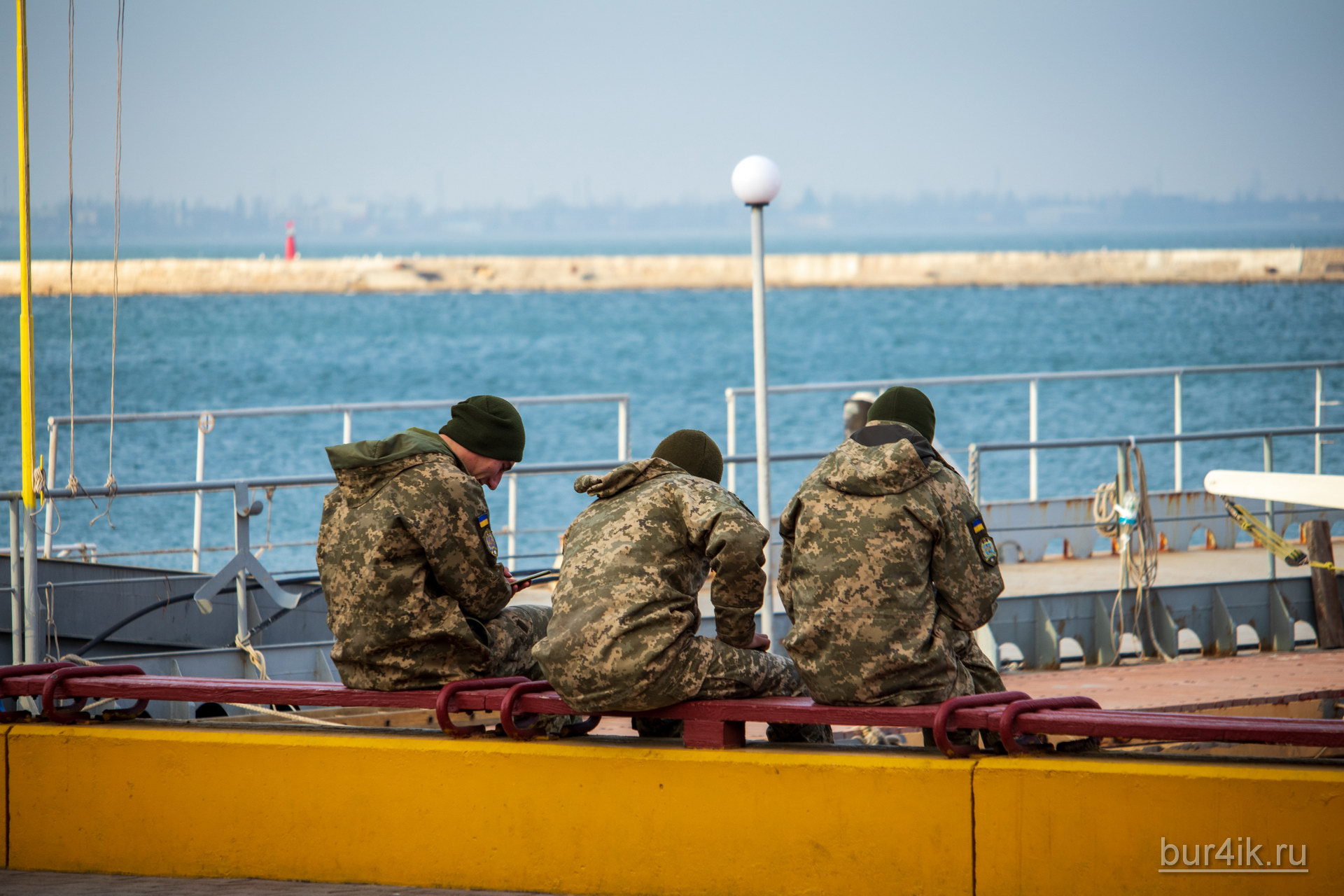 Военные сидят на скамейке у причала в порту в городе Одесса 4