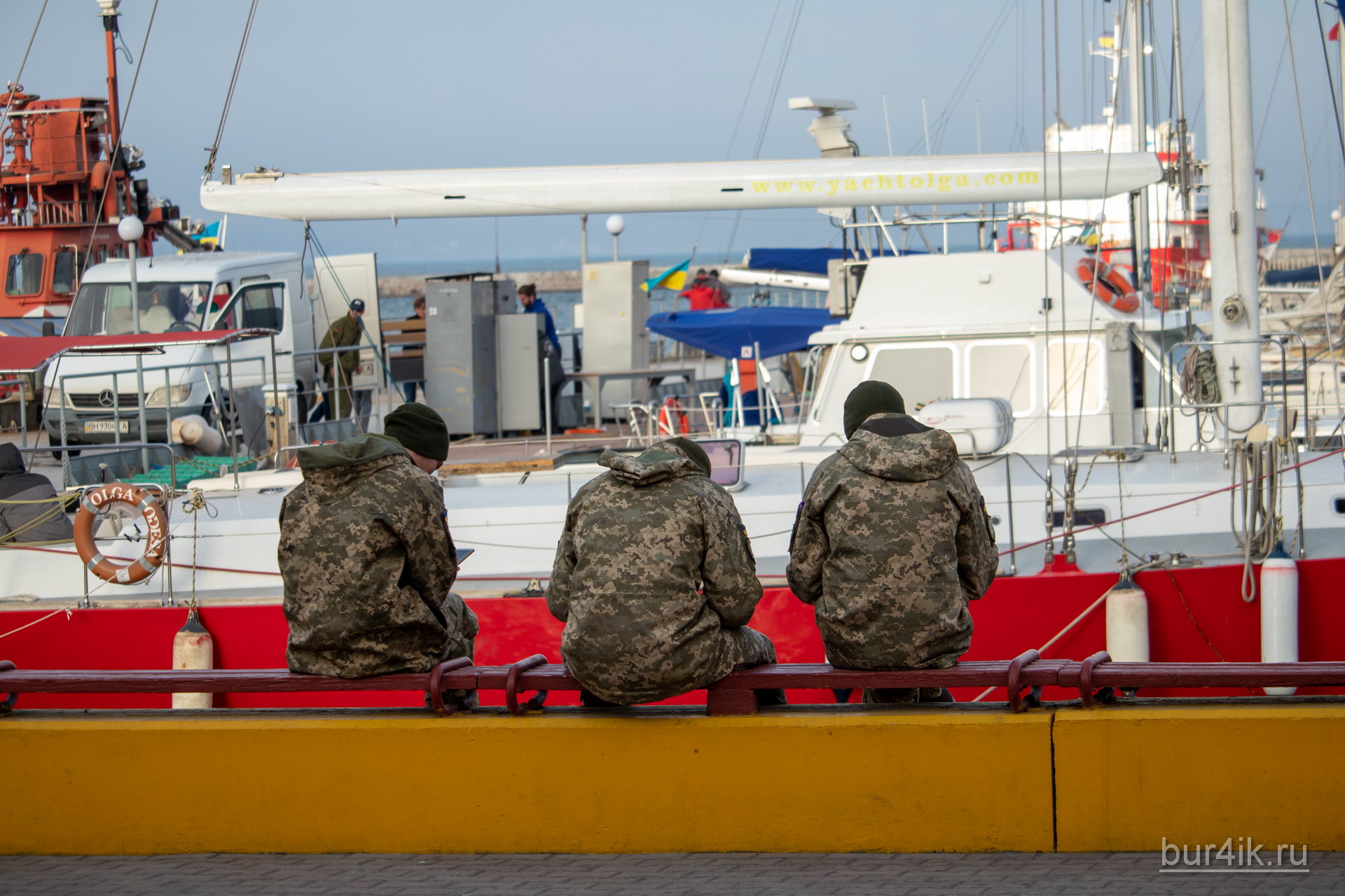 Военные сидят на скамейке у причала в порту в городе Одесса 5