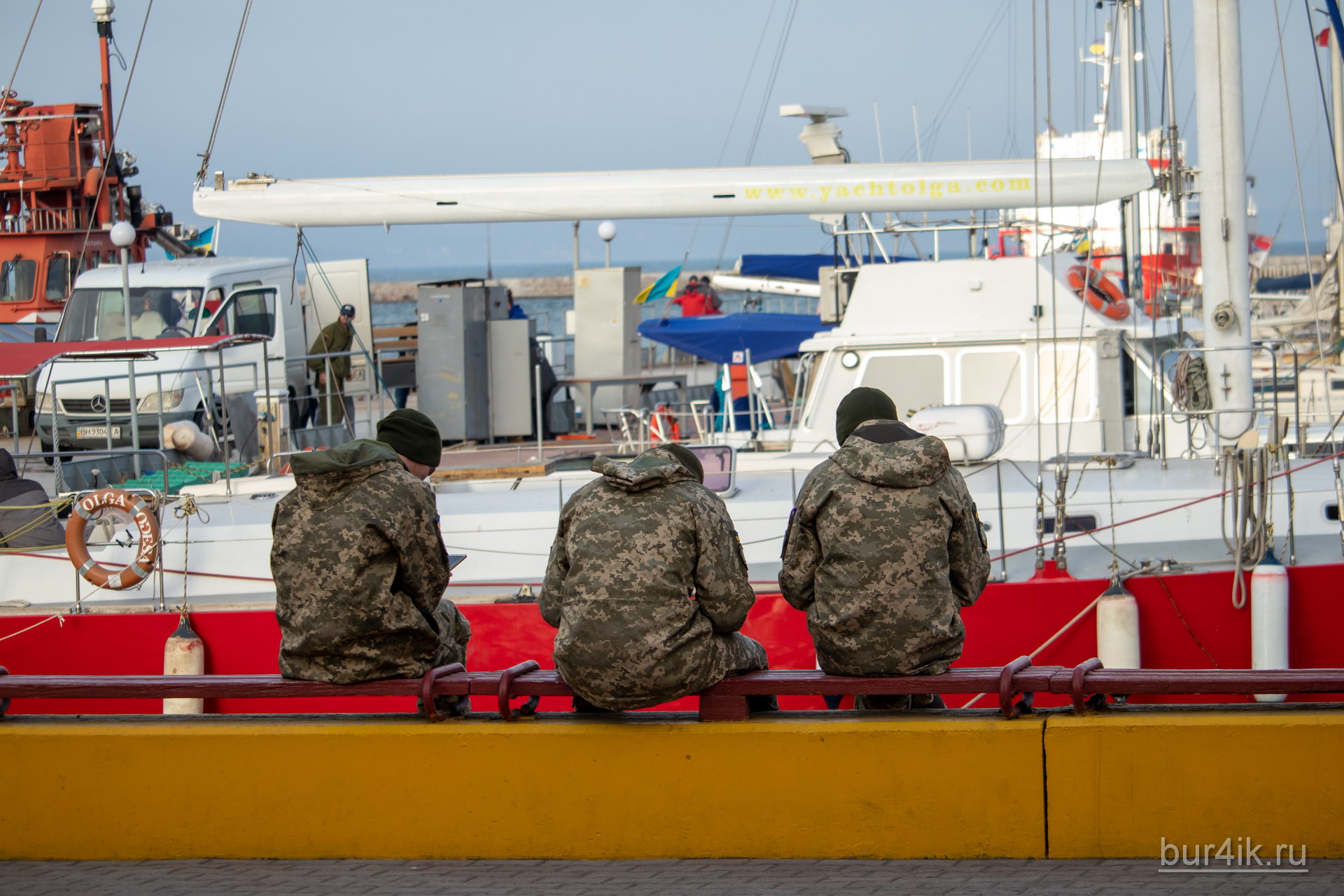 Военные сидят на скамейке у причала в порту в городе Одесса 6