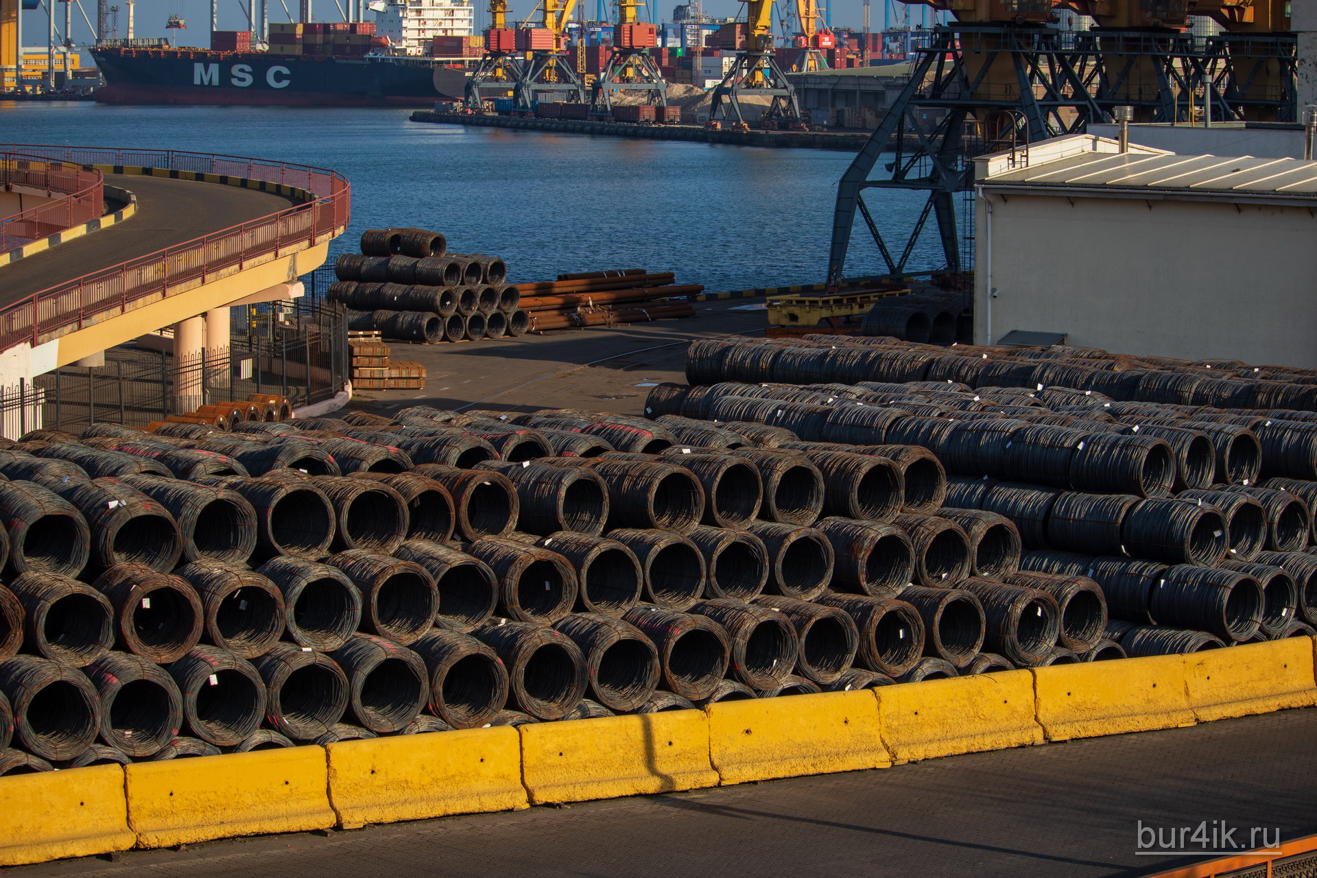Горы металлической проволоки в бухтах ждут отправки на судне по морю в порту