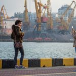 Две сестры фотографируются на телефон в порту города Одесса