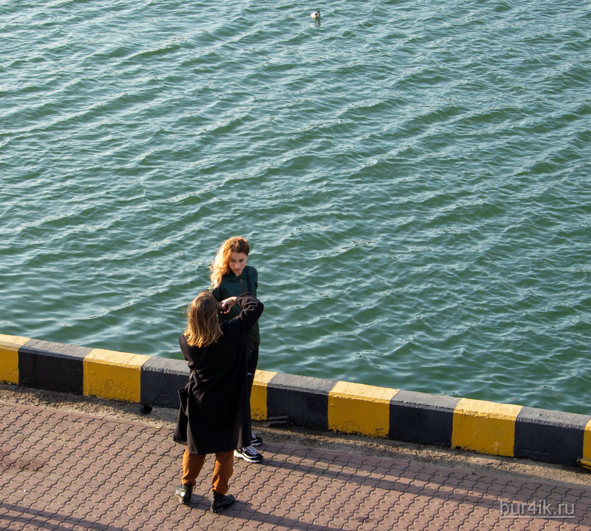 Девушка фотографирует подругу в порту города Одесса 2