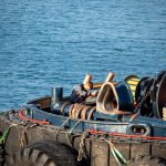 Моряк вяжет канаты на палубе буксира в порту Одесса