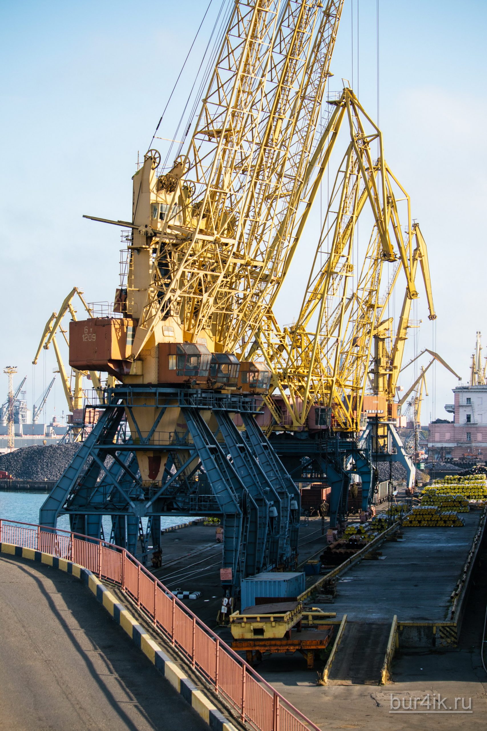 Покрашенные желтой краской краны в порту у моря в городе Одесса 21