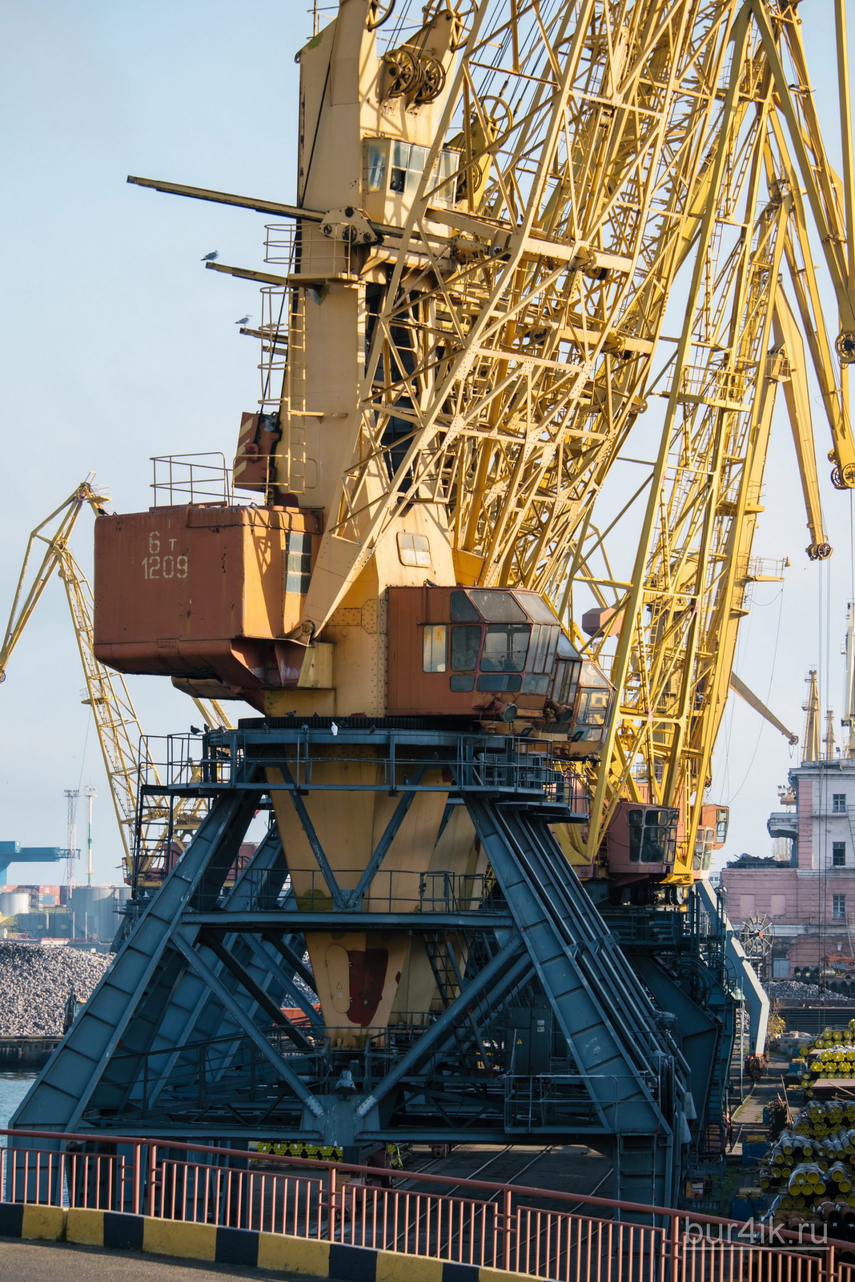 Покрашенные желтой краской краны в порту у моря в городе Одесса 24