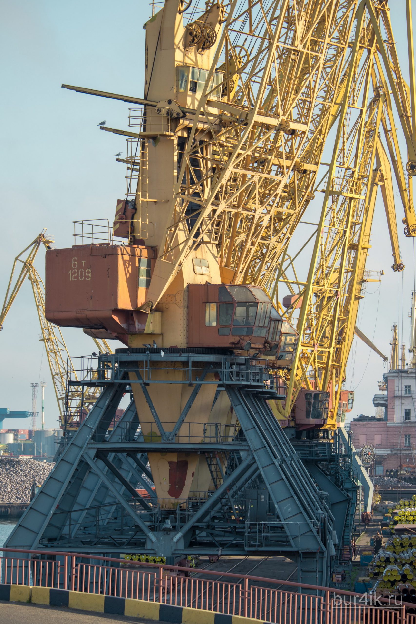 Покрашенные желтой краской краны в порту у моря в городе Одесса 25