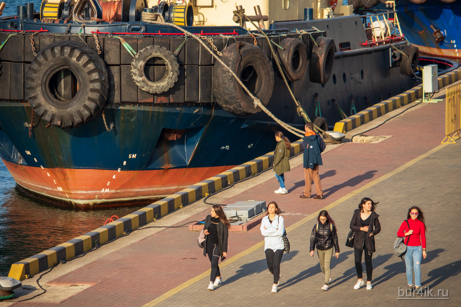 Пять девушек гуляют в порту у моря в городе Одесса