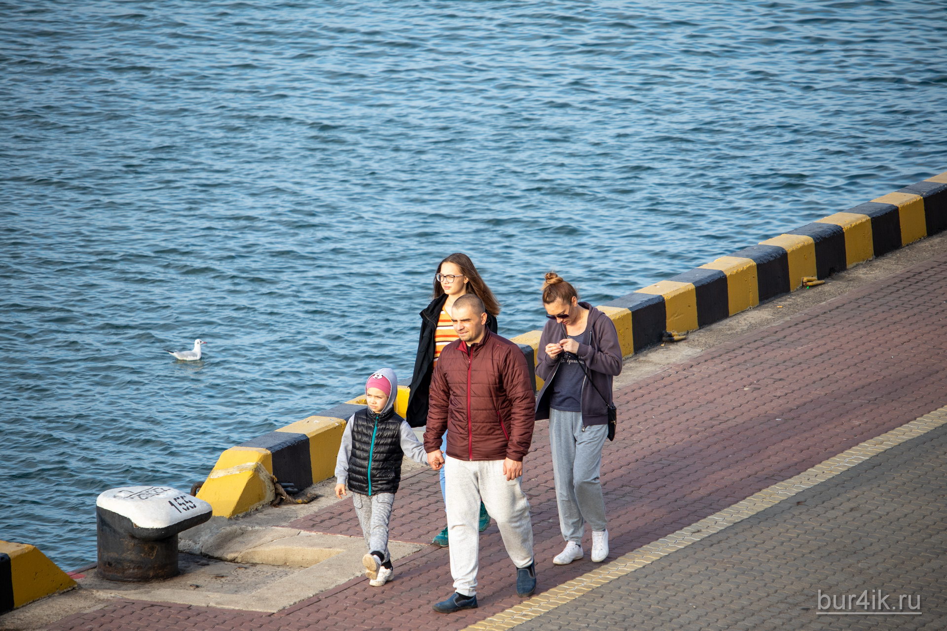 Семья прогуливается у воды в порту города Одесса 2
