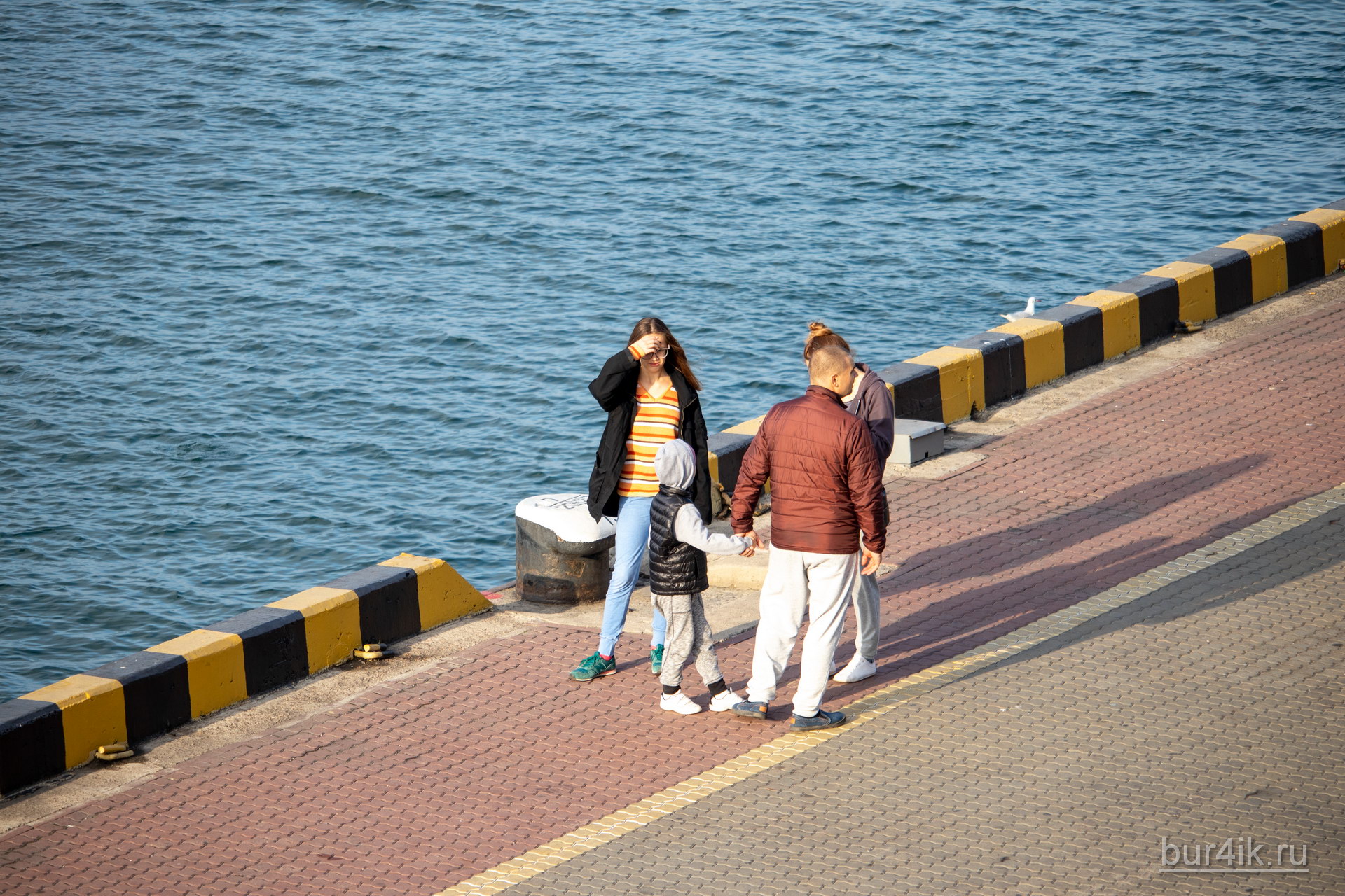 Семья прогуливается у воды в порту города Одесса 3