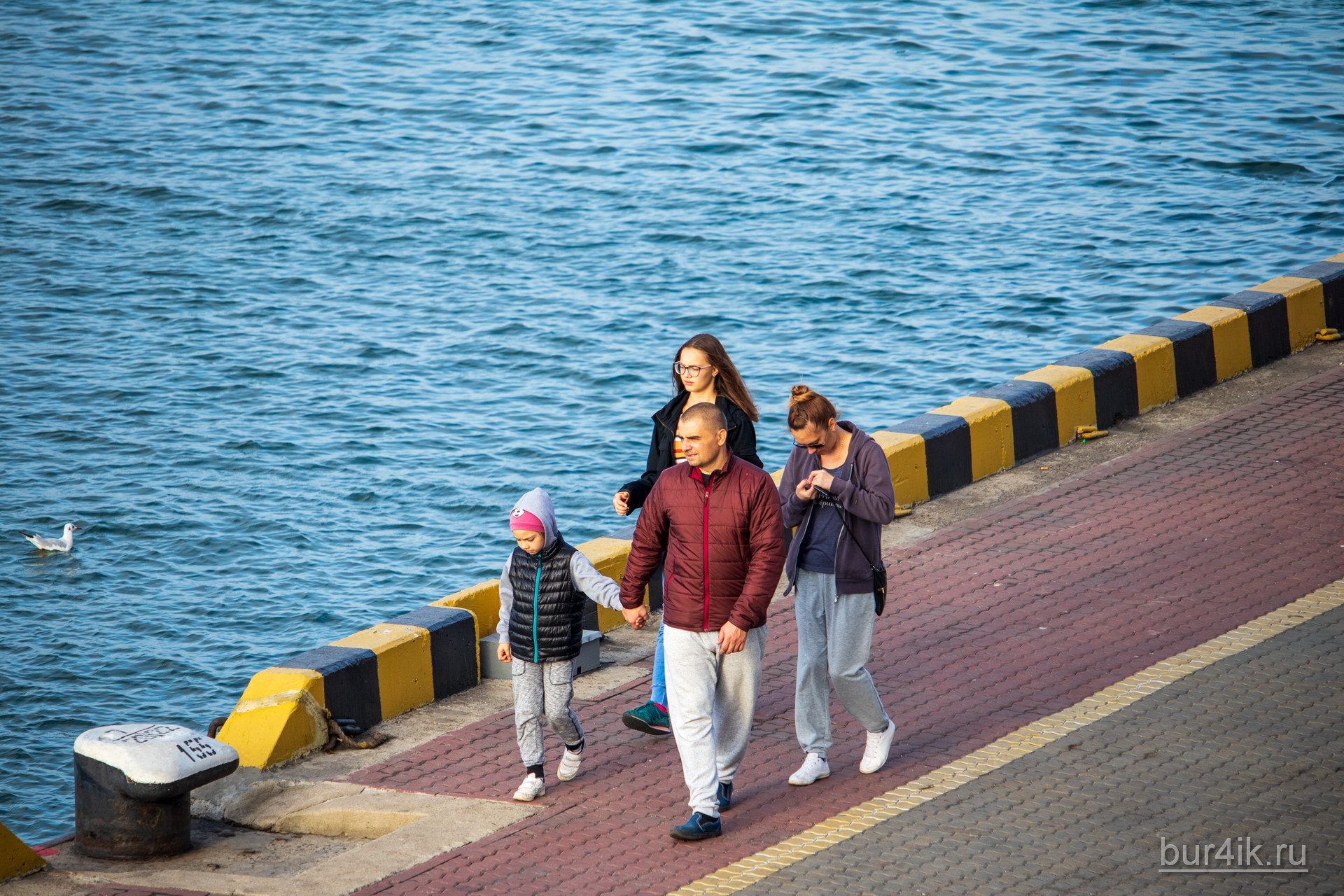 Семья прогуливается у воды в порту города Одесса