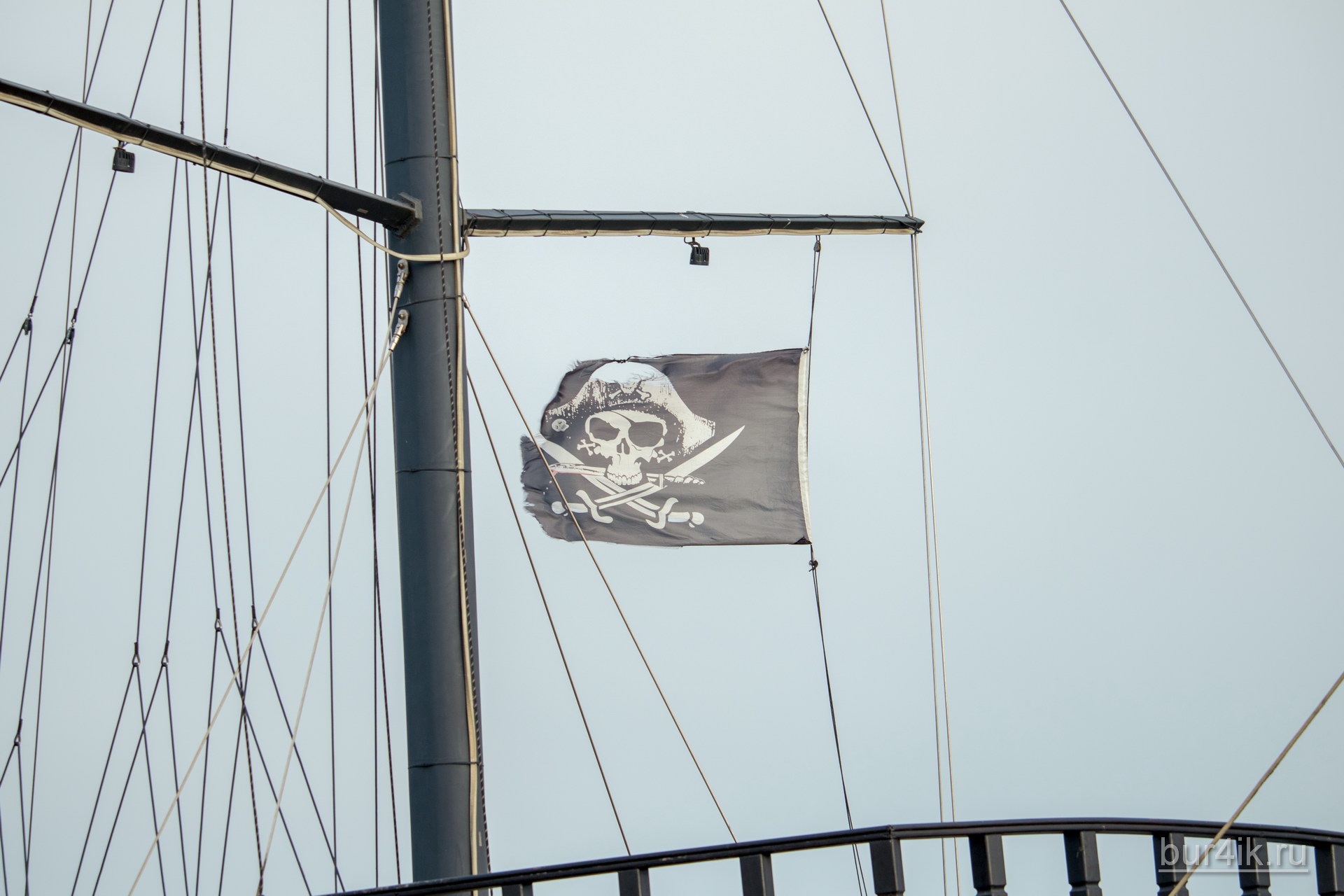 Черный пиратский флаг с черепом и саблями на мачте фрегата 10