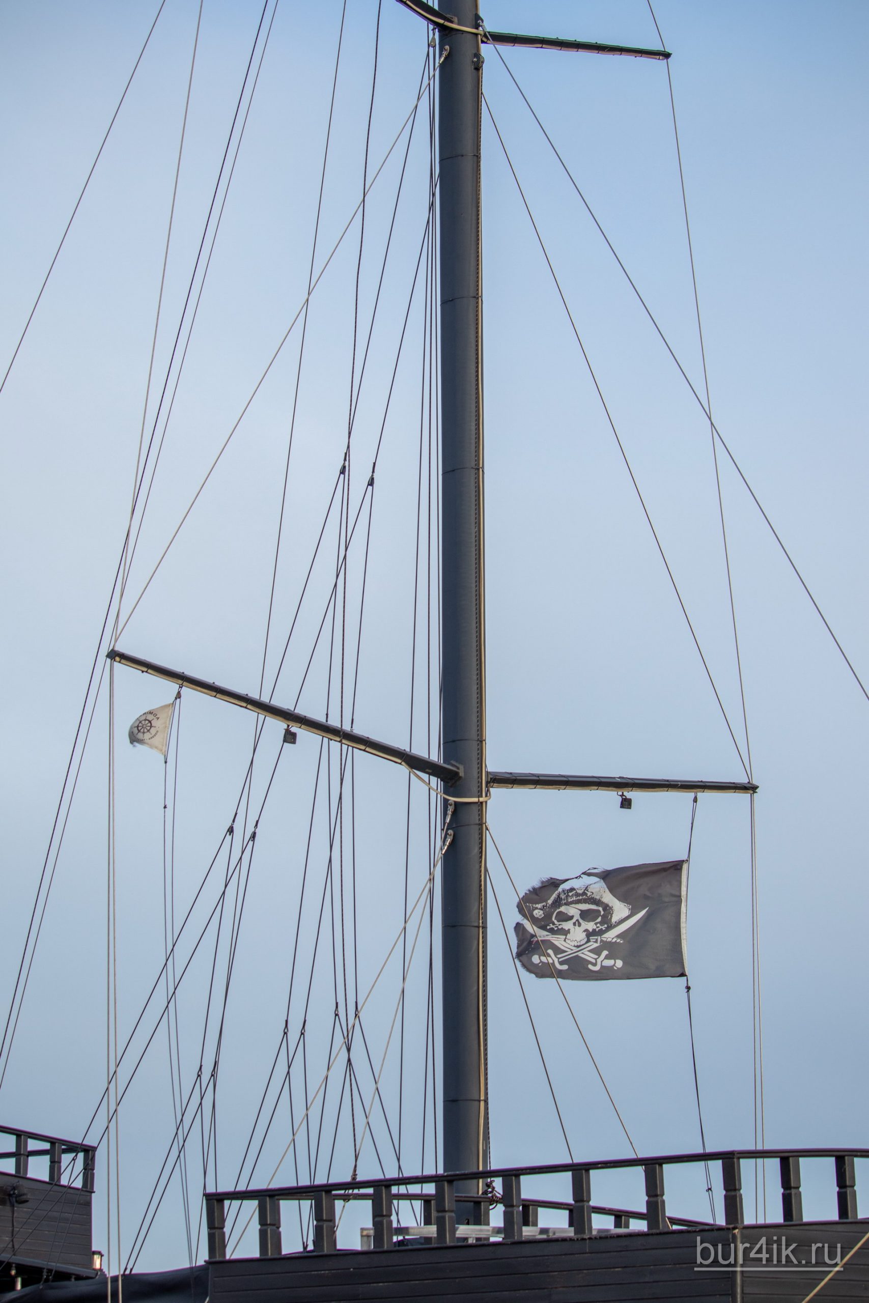 Черный пиратский флаг с черепом и саблями на мачте фрегата 11