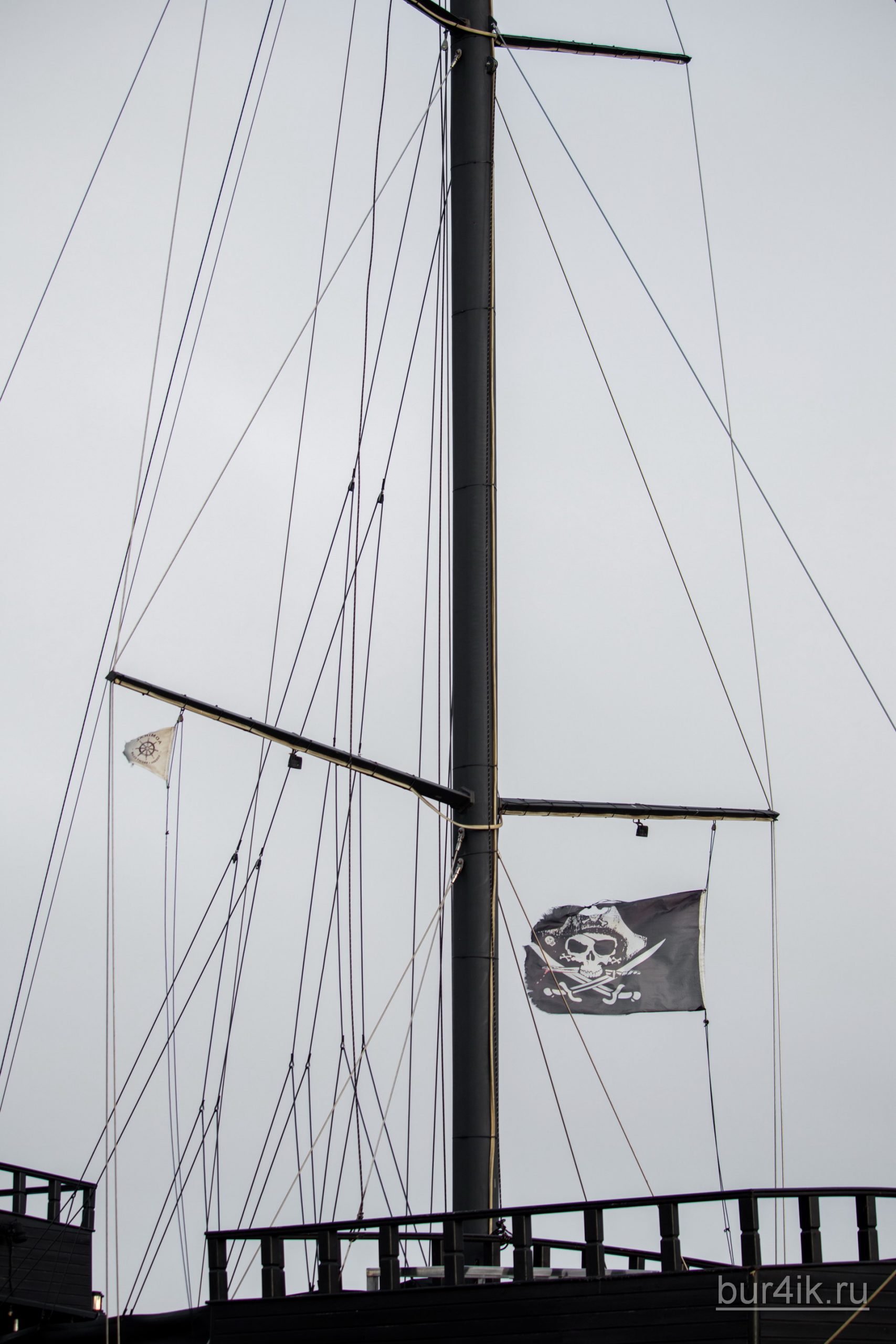 Черный пиратский флаг с черепом и саблями на мачте фрегата 12