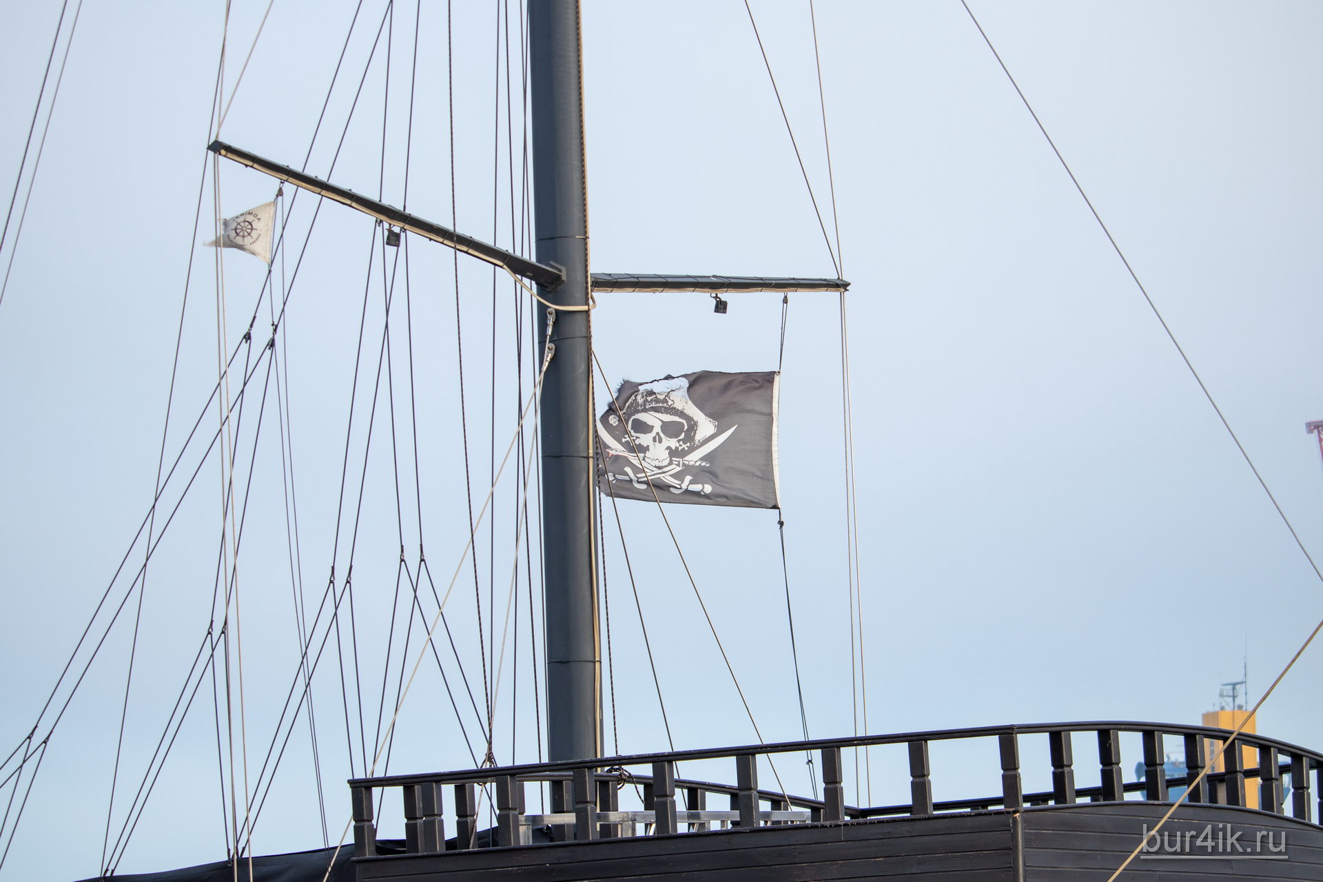 Черный пиратский флаг с черепом и саблями на мачте фрегата 2