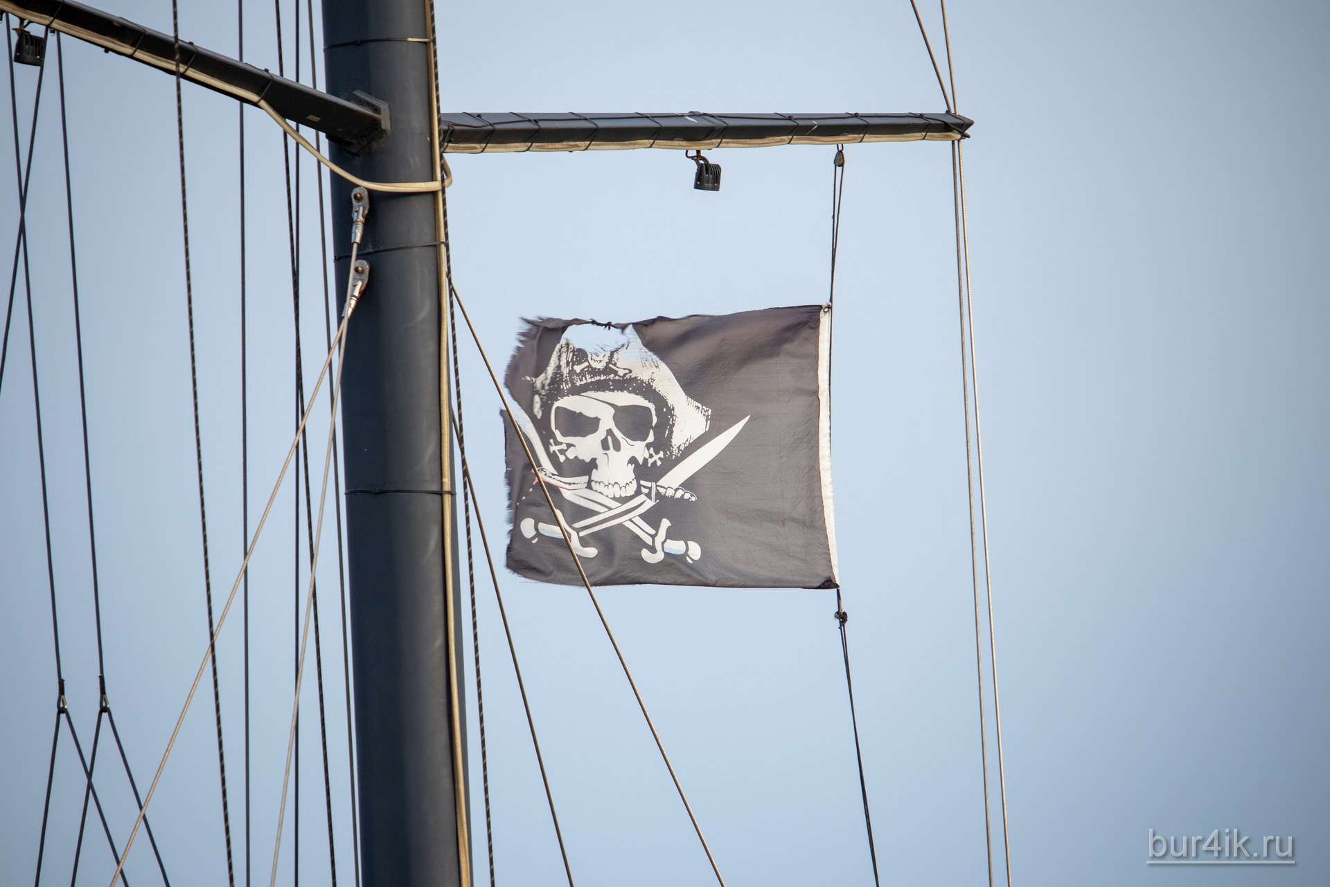 Черный пиратский флаг с черепом и саблями на мачте фрегата 3