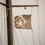 Черный пиратский флаг с черепом и саблями на мачте фрегата 4
