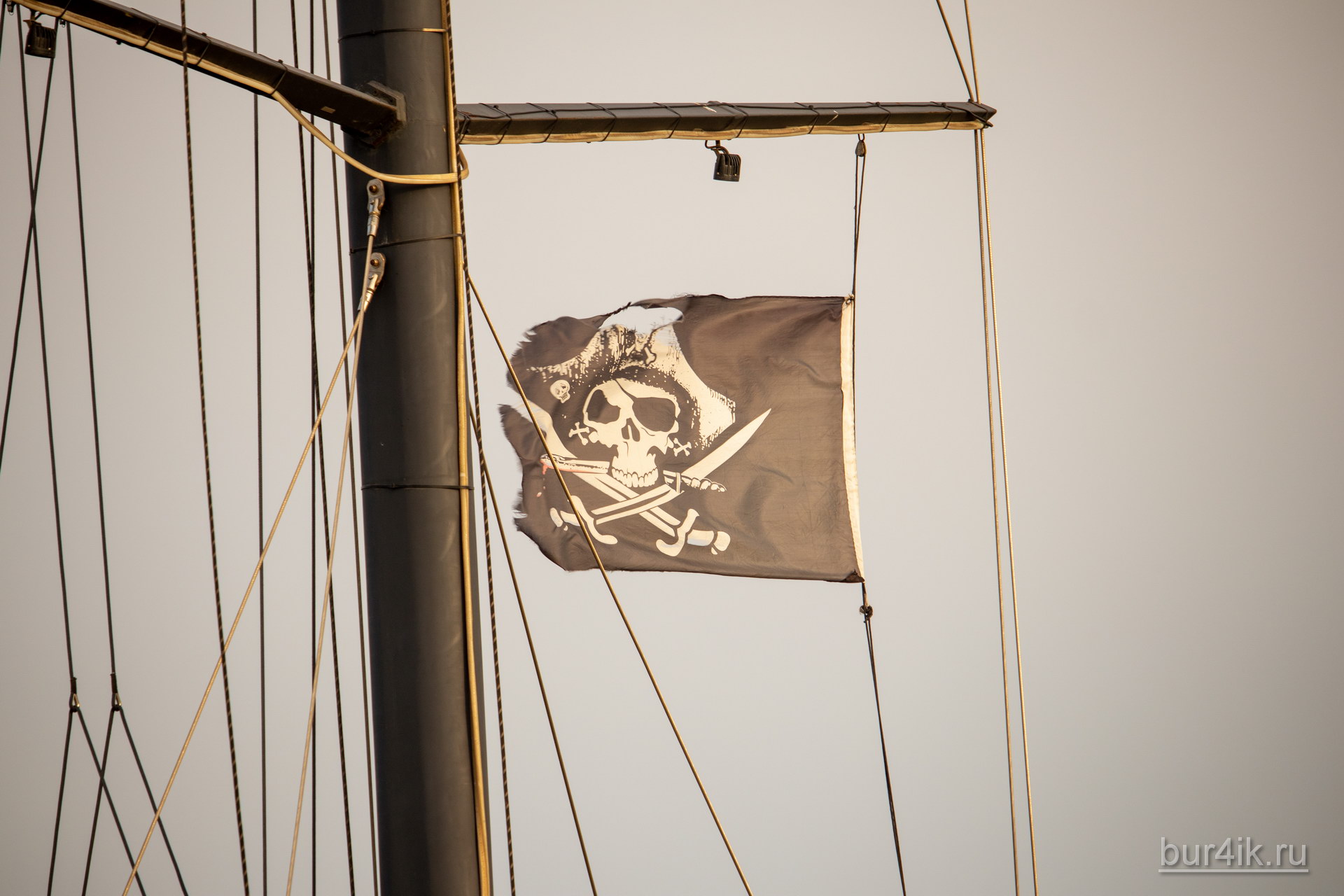 Черный пиратский флаг с черепом и саблями на мачте фрегата 4