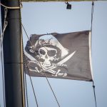 Черный пиратский флаг с черепом и саблями на мачте фрегата 5