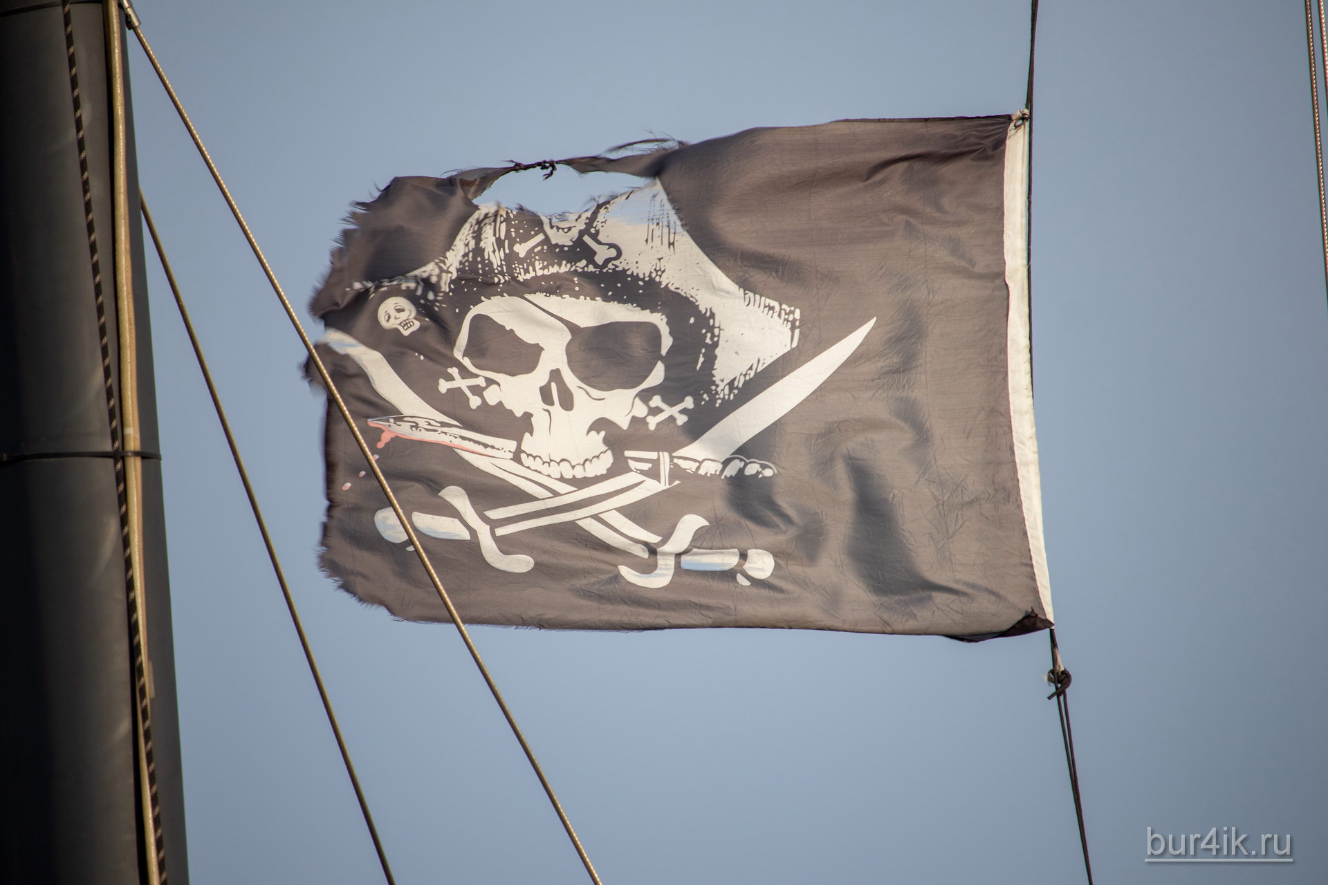 Черный пиратский флаг с черепом и саблями на мачте фрегата 6