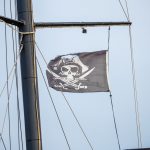 Черный пиратский флаг с черепом и саблями на мачте фрегата 7