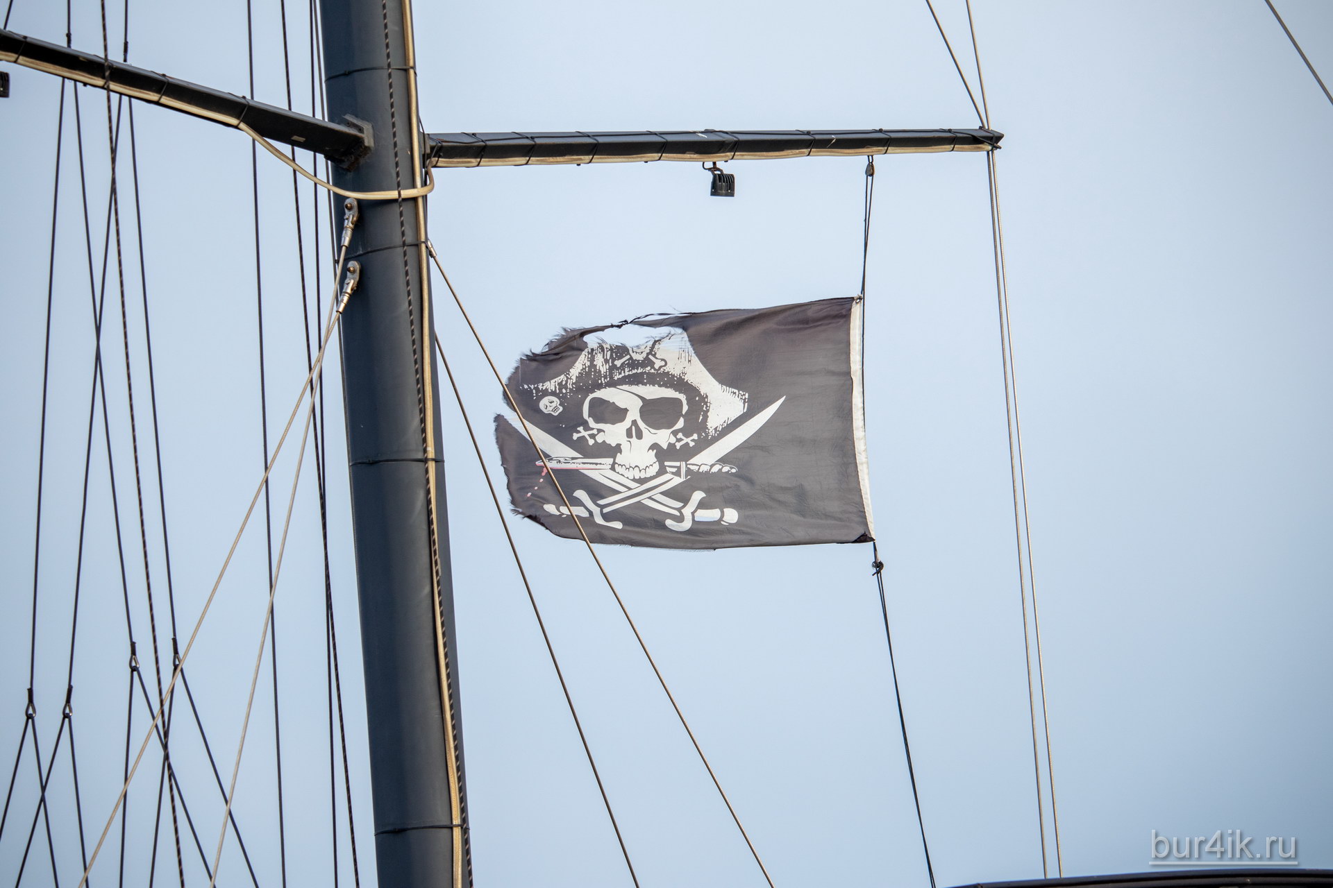 Черный пиратский флаг с черепом и саблями на мачте фрегата 7