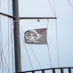 Черный пиратский флаг с черепом и саблями на мачте фрегата 9